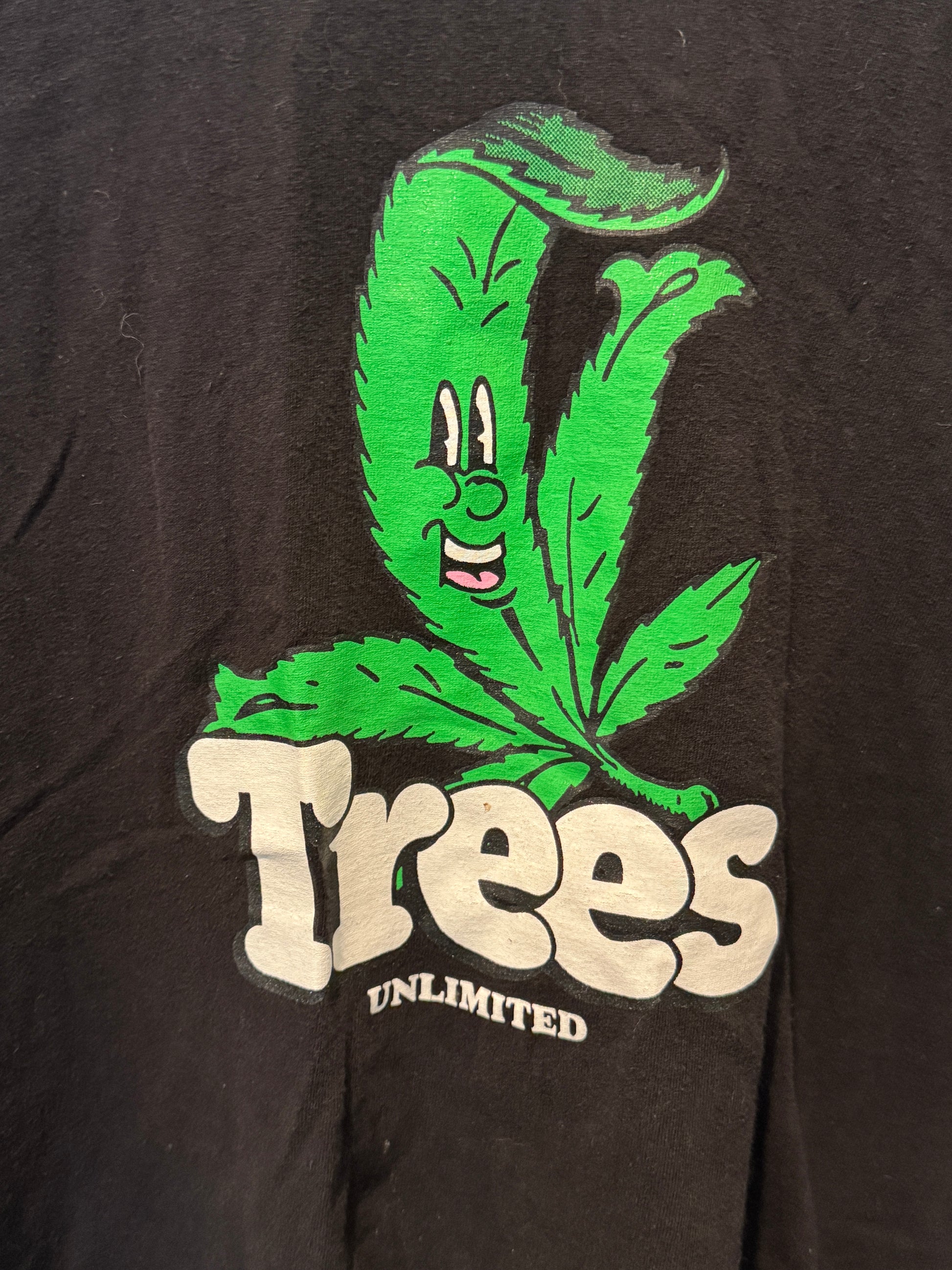 Black t-shirt with green cannabis leaf graphic and 'Trees Unlimited' text.