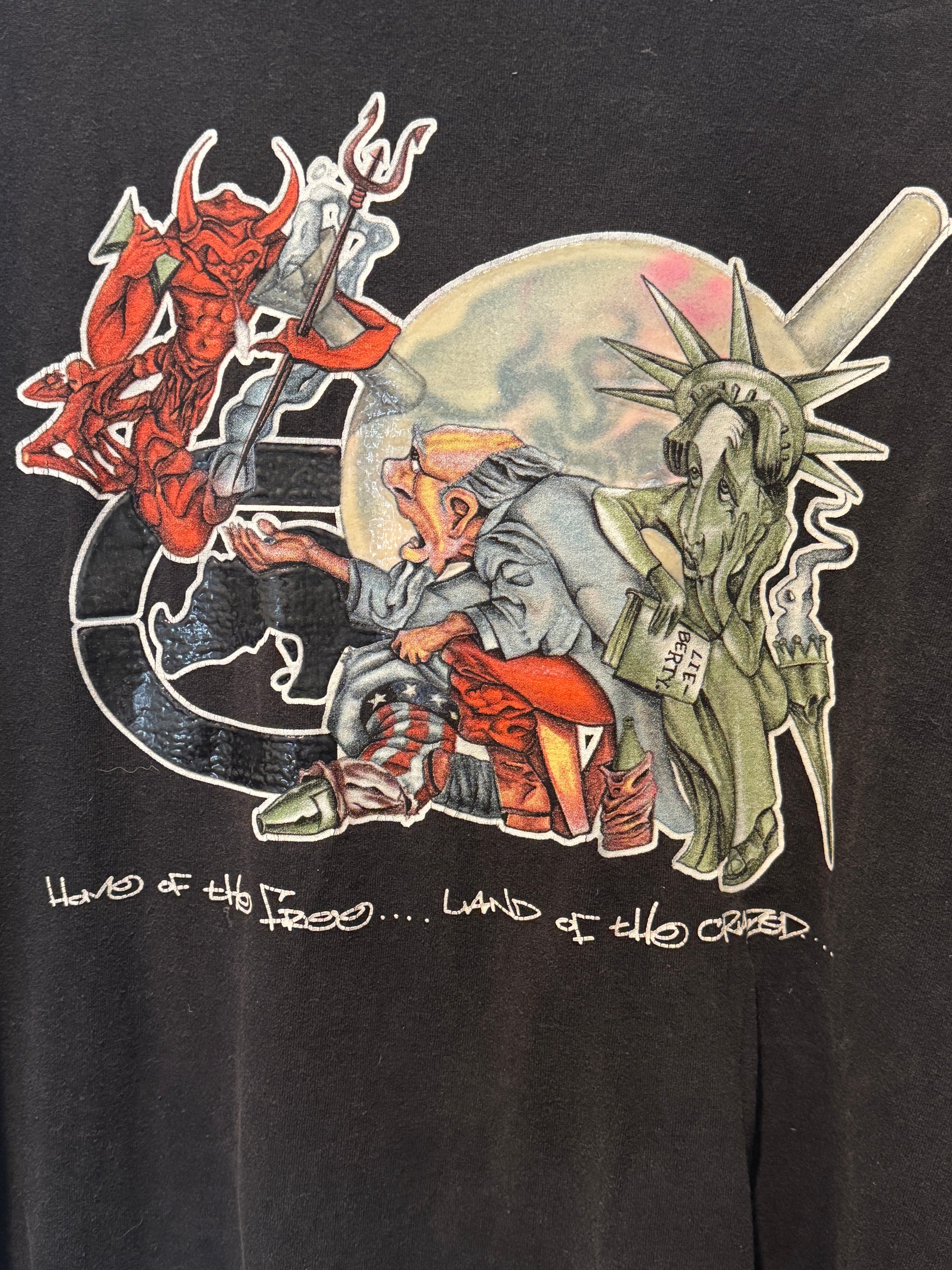 Black t-shirt with a graphic design of a person holding a sword, Statue of Liberty, and text on a black background.