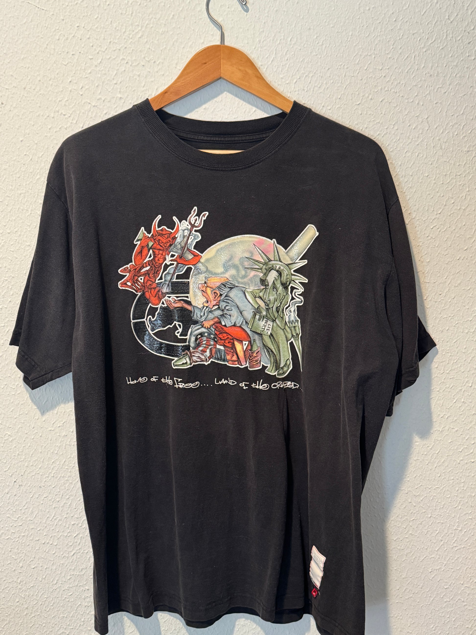 Black t-shirt with colorful graphic design on a beige surface