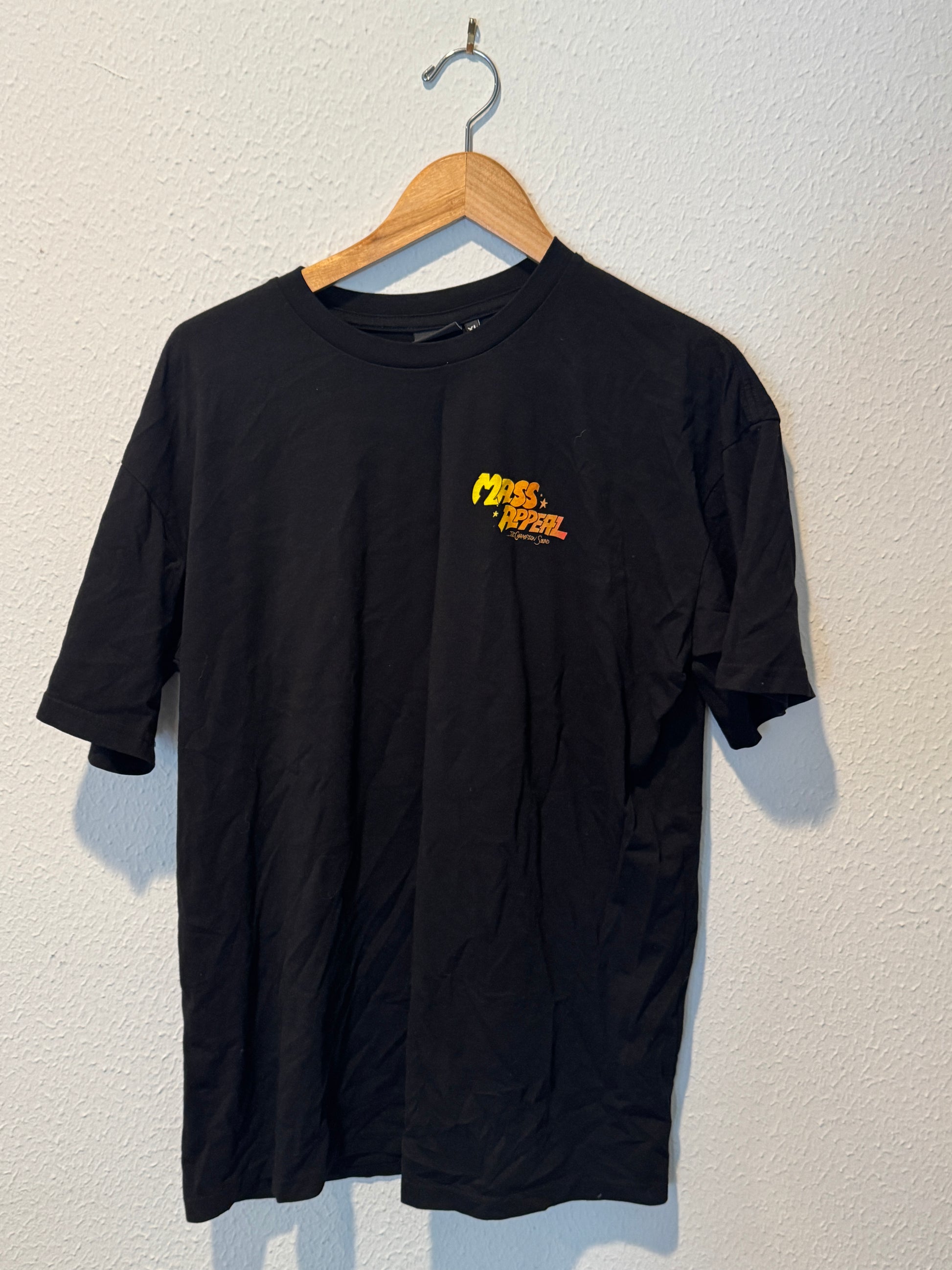 Black long-sleeve shirt with a logo on a wooden hanger against a light background