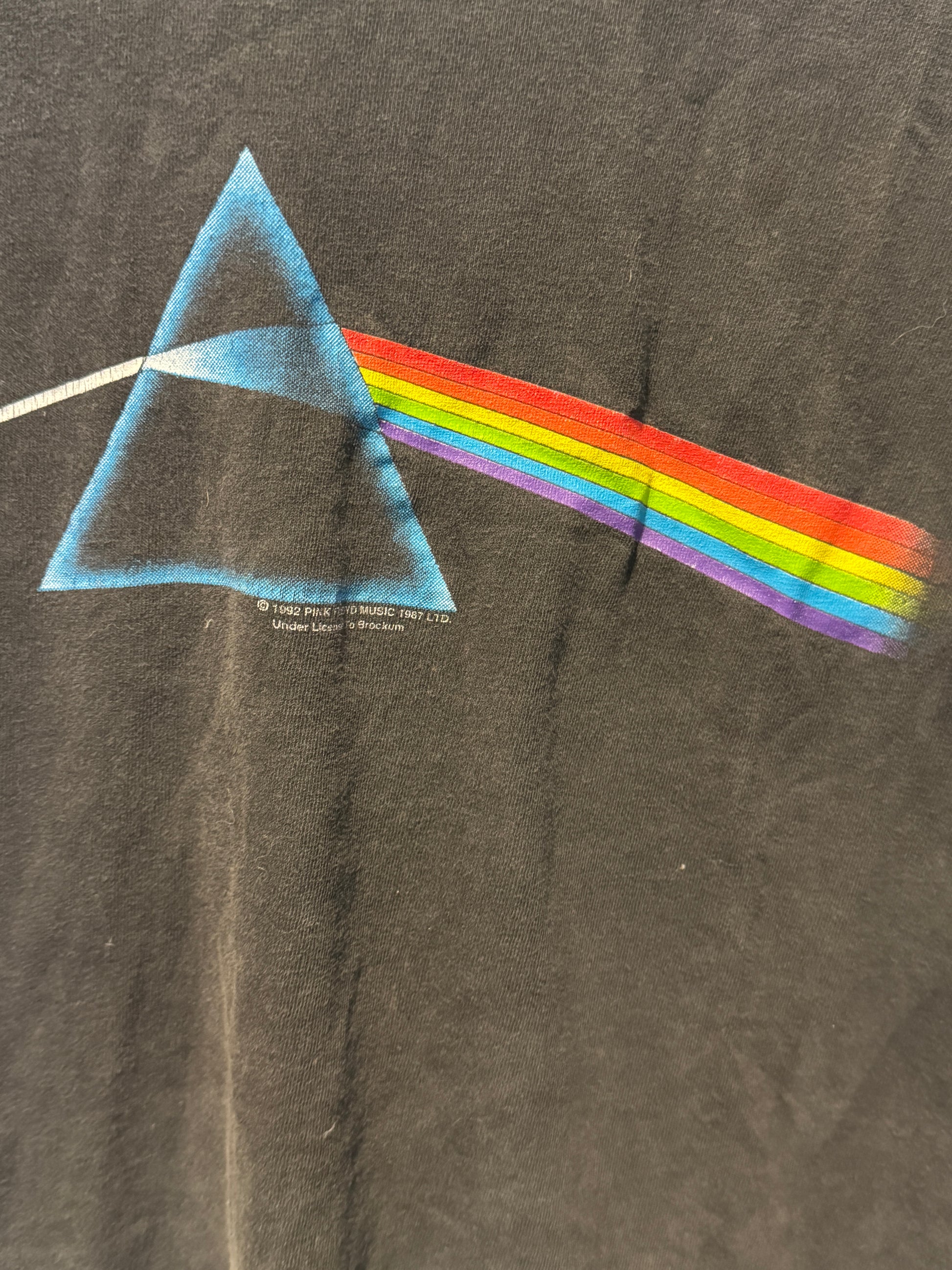 T-shirt with a colorful rainbow and triangle design on a dark fabric background