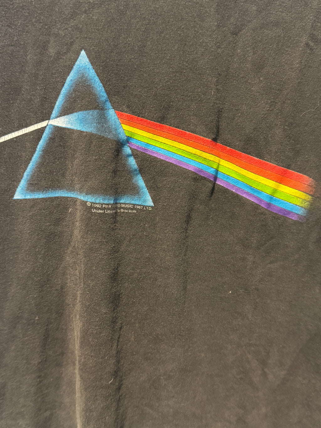 T-shirt with a colorful rainbow and triangle design on a dark fabric background