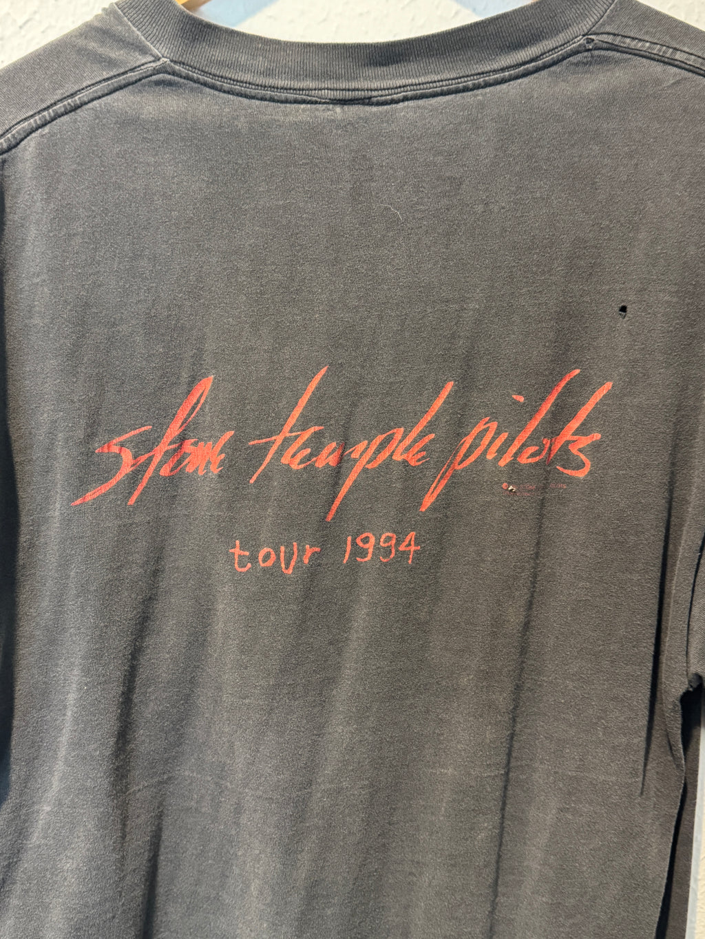 Gray tank top with red text on a plain background vintage